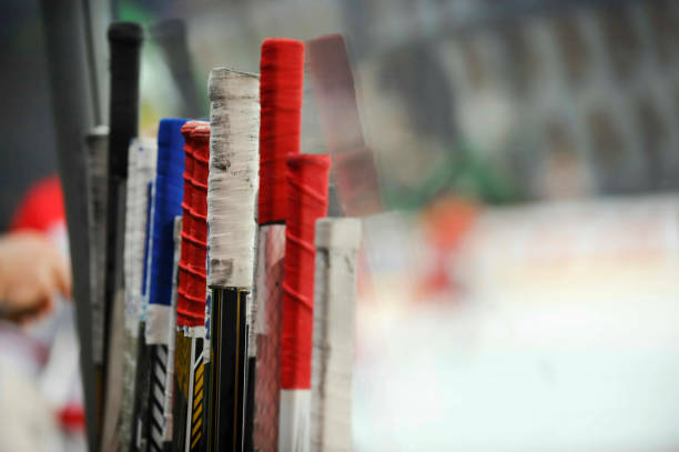 Close up of a hockey stick and street/roller hockey ball on a white background with natural shadows.  See also