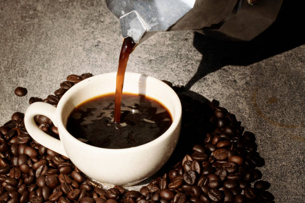 istock coffee pouring to cup with coffee bean on black background 1125898770