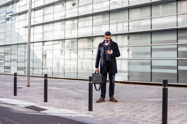 istock Middle aged man with a briefcase and a phone on the street 1125899401