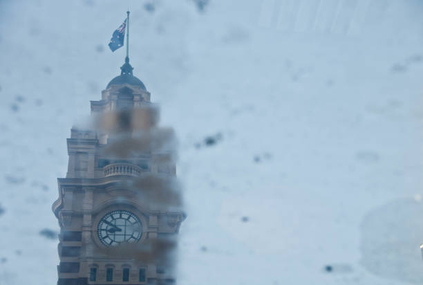 vintage klasyczny clocktower z melbourne flinders street odbicie stacji kolejowej od stawu deszczowego w deszczowy dzień w połowie zimy. - melbourne australia clock tower clock zdjęcia i obrazy z banku zdjęć