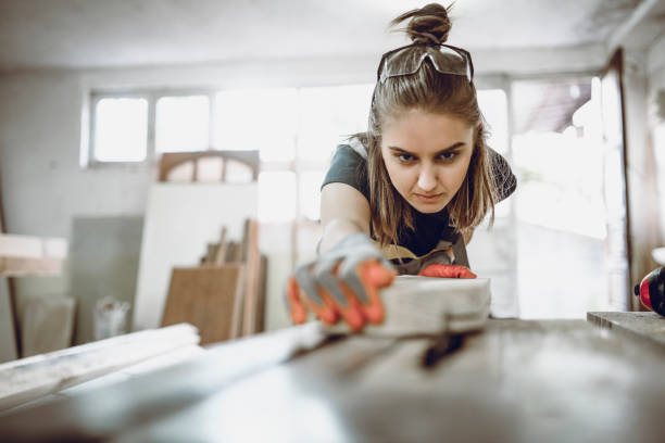 istock Cute Female Carpenter Adjusting Plank Position On Table 1125901764