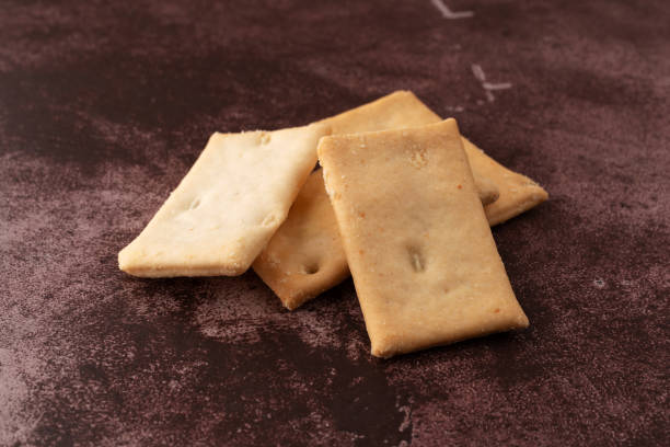 istock Cheese flavor crostini crackers on a maroon counter top. 1125903020