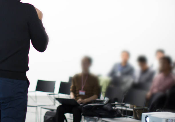 istock Presentation Projector in Seminar with Audience in Training. Speaker in Meeting at Business Event. Expert Presenter Giving Talk to Young Group of People. People Listen to Speaker Presentation. 1125905617