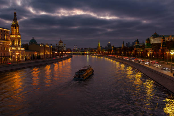 istock Pleasure boat floating on Moskva river in evening against dramatic cloudy sky. Landscape of the Moscow historical center 1125906324