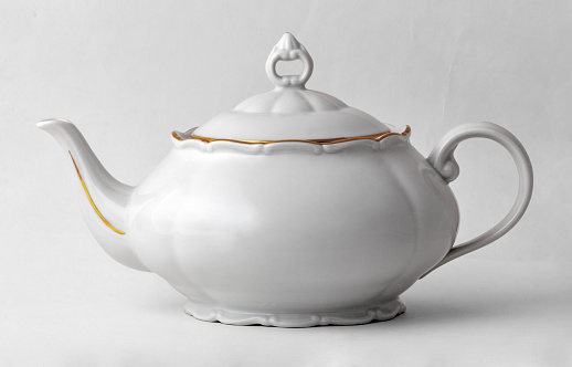 White teapot with golden rim in classic style isolated on white background with clipping path