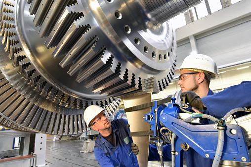 trabajadores de montaje y la construcción de turbinas de gas en una fábrica industrial moderna photo