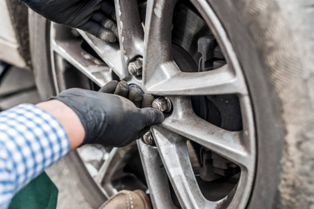istock Hands in gloves fixing nuts on car wheel closeup 1125909508