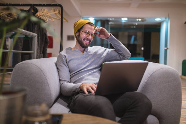 Handsome young man watching funny videos online Handsome and successful young freelancer working in a coworking space in city center during winter. i see you meme stock pictures, royalty-free photos & images