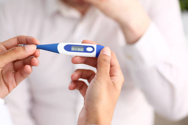 hands of a female doctor holding a thermometer hands of a female doctor holding a thermometer with a patient's high temperature in hand fever stock pictures, royalty-free photos & images