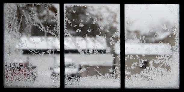 istock Closeup blur winter view from silhouette window with snowflakes 1125912313