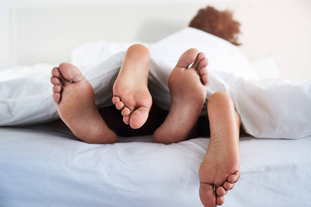 I like it when you're this close Shot of a couple’s feet poking out from under the sheets sex and reproduction stock pictures, royalty-free photos & images