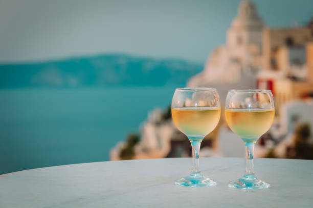 romantic vacation in Greece -two wine glasses in Santorini romantic vacation in Greece -two wine glasses in Santorini with sea view table ledge stock pictures, royalty-free photos & images