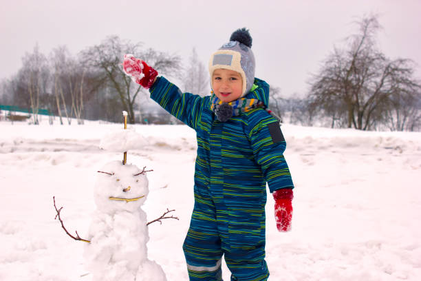istock A four-year-old child, a boy, smiling sculpts a snowman. 1125914003