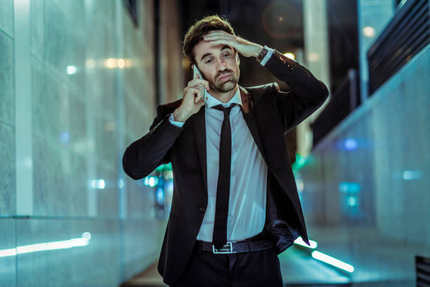 istock tired young businessman talking on the phone 1125914763