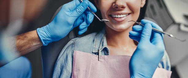 Woman in dental clinic Attractive young woman in stomatology clinic with male dentist. Healthy teeth concept. dental equipment stock pictures, royalty-free photos & images