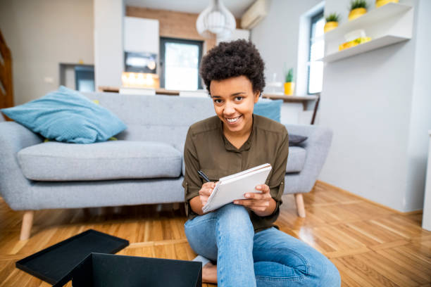 istock Young African American woman making notes and packing 1125918478