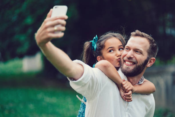istock Father with daughter taking selfie among nature 1125919422