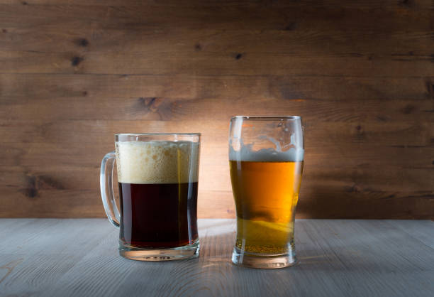 istock Two glasses of different colored beer on wooden background 1125920692