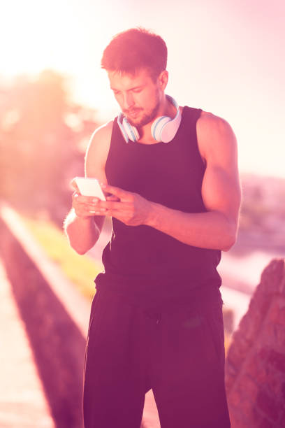 istock Man with earphones using smartphone 1125921638