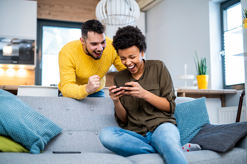 Young couple using smart phones in the living room