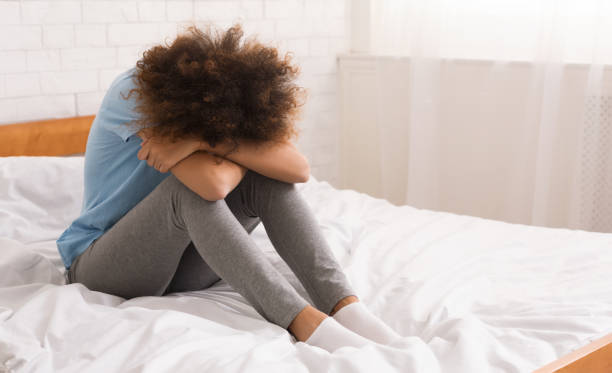 istock African-american woman suffering from depression sitting on bed 1125924716