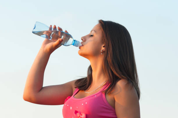 istock Young woman drinking water in the summer nature 1125929197