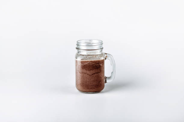 istock Fresh protein shake, milk with cocoa in a glass jar on a white background 1125929947