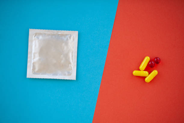 test de grossesse. le résultat est positif avec deux bandes et préservatif avec contraceptif sur fond coloré, pilule contraceptive, safe sex, santé concep - contraceptive sex education birth control pill condom photos et images de collection