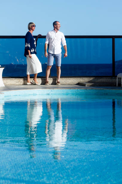 Mature Couple Conversing by the pool in a luxurious hotel