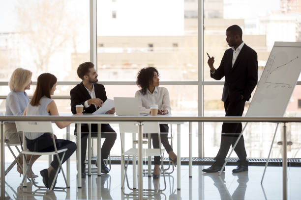 proprietário da empresa preto faz apresentação aos trabalhadores durante reunião - boardroom presentation - fotografias e filmes do acervo