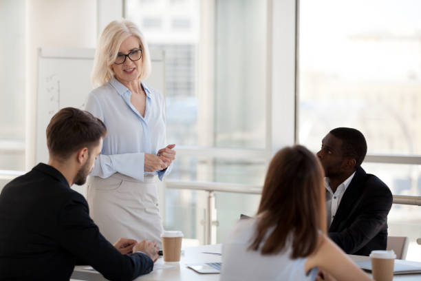 istock Serious experienced team leader discussing with colleagues at meeting 1125941787
