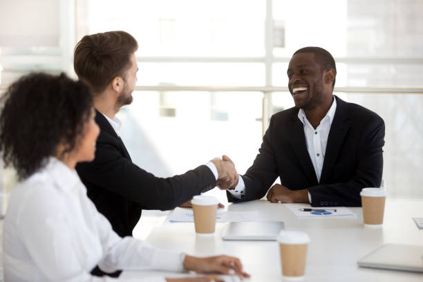 istock Diverse workers greeting each other in briefing shaking hands 1125941843