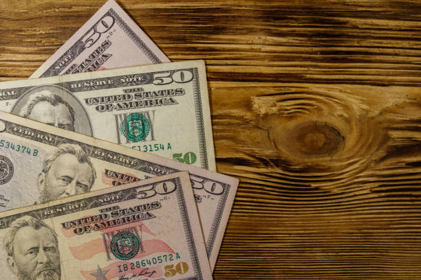 istock Fifty dollars banknotes on wooden background. Top view 1125942859