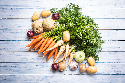 Top of view assortment fresh vegetables on wooden table.