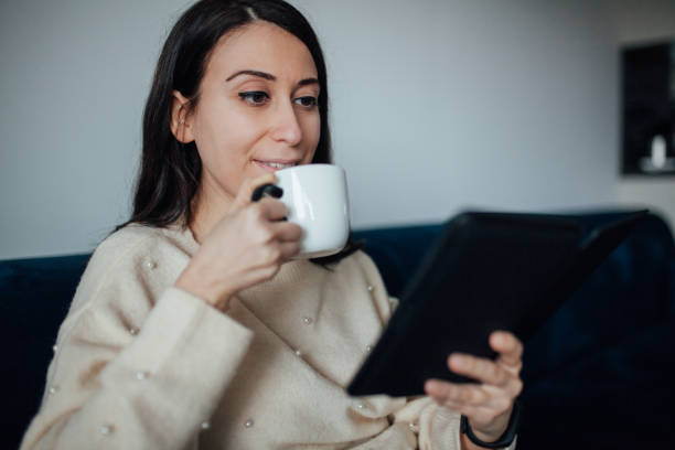 istock Woman reading e book at home 1125947081