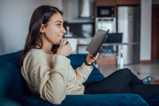 istock Woman reading e book at home 1125947084