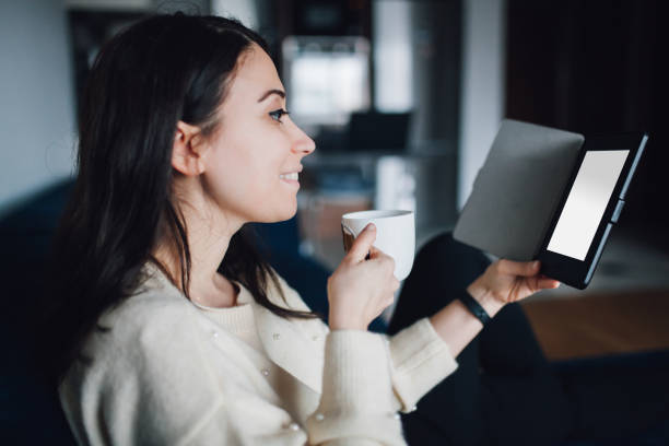 istock Woman reading e book at home 1125947088