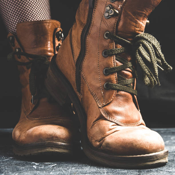 istock Female legs shod in old Hiking boots 1125948053