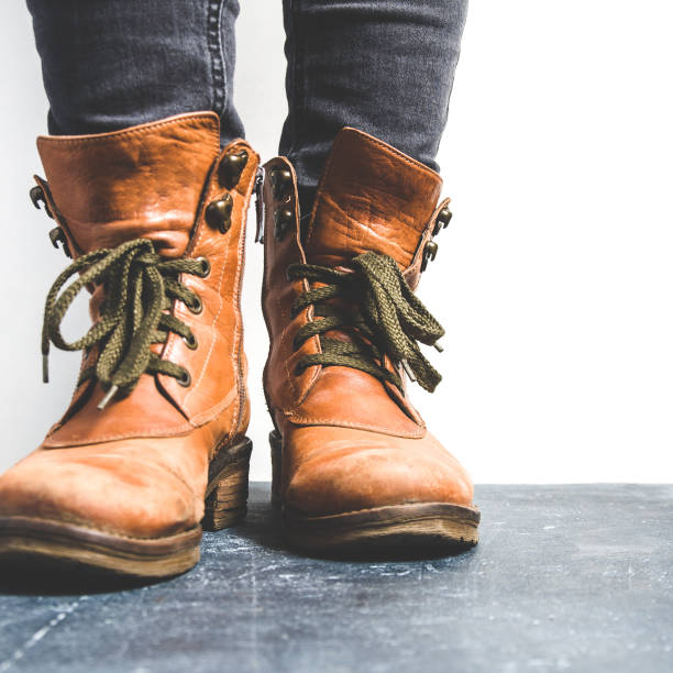 istock Female legs shod in old Hiking boots 1125948066