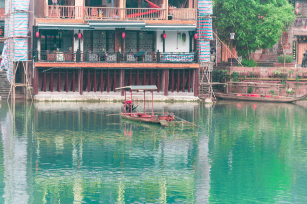 FENGHUANG, HUNAN, CHINA - DECEMBER 12 2018 : traditional old houses located at Fenghuang county in Hunan, and view of wooden boat