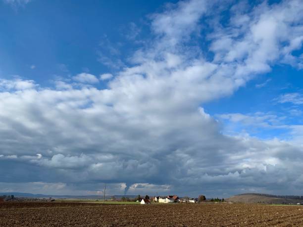 istock Farmland and typical german small village under dramatic sky, january 1125949795