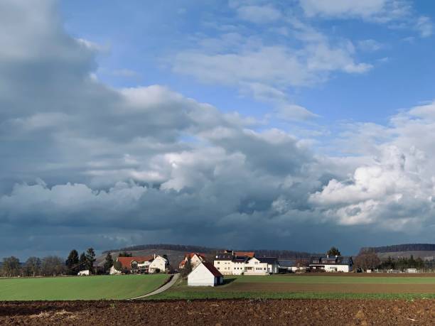 istock Farmland and typical german small village under dramatic sky, january 1125949805