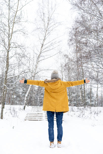 istock Girl in winter forest in yellow jacket 1125950117