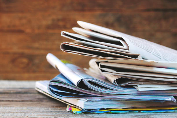 istock Newspapers and magazines on old wood background. Toned image. 1125950396