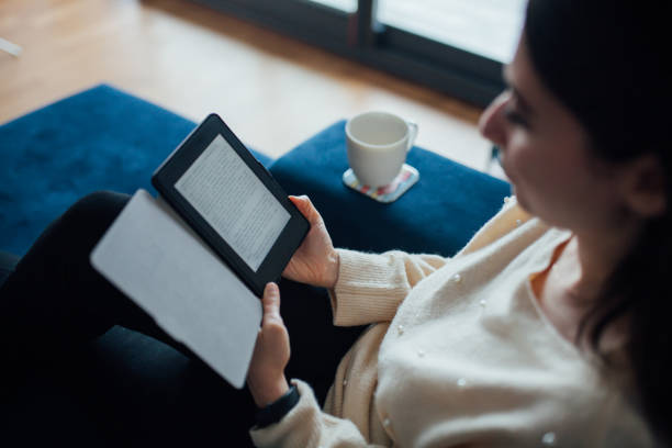 istock Woman reading e book at home 1125950480