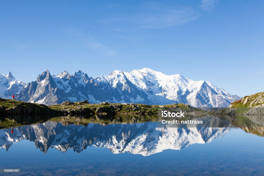 Mountain running in nature A runner explores the mountain trails near Chamonix in France, the Month Blanc is reflected in the lake Mont Blanc Stock Photo