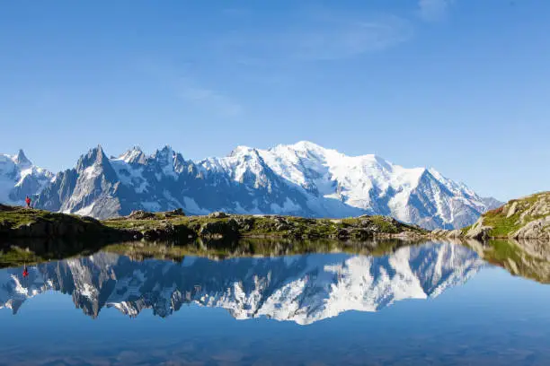 A runner explores the mountain trails near Chamonix in France, the Month Blanc is reflected in the lake