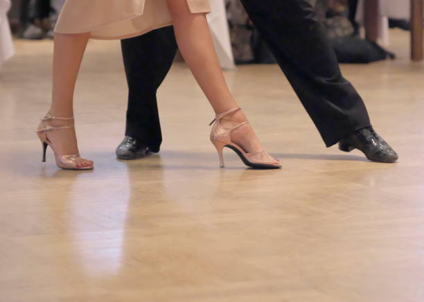 Graceful dance couple tangoing at the ballroom.