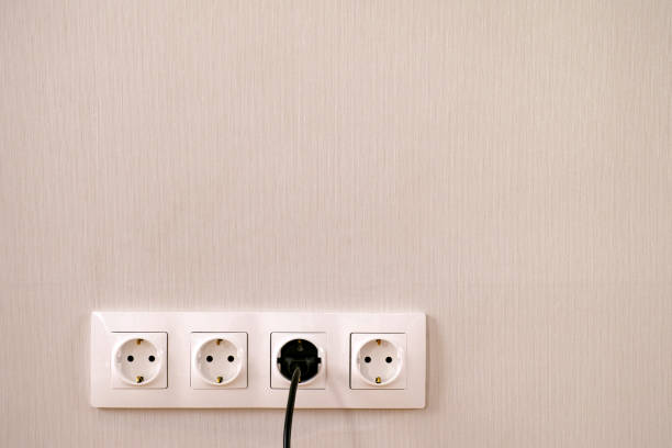 istock Four power sockets, black lead and plug on the wall. 1125952671