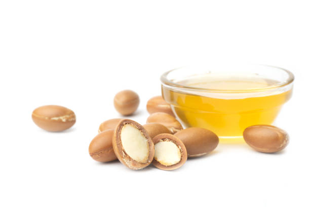 Woman manually grinding argan nuts to extract argan oil using a traditional hand mill, a common artisan practice in morocco, highlighting sustainable production and cultural heritage